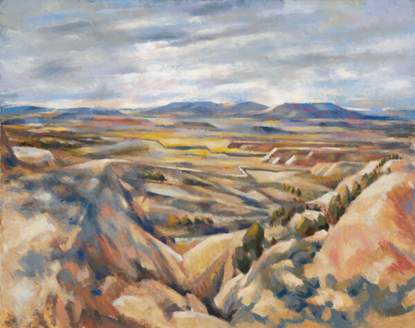A road leads down from a mesa to the valley below.