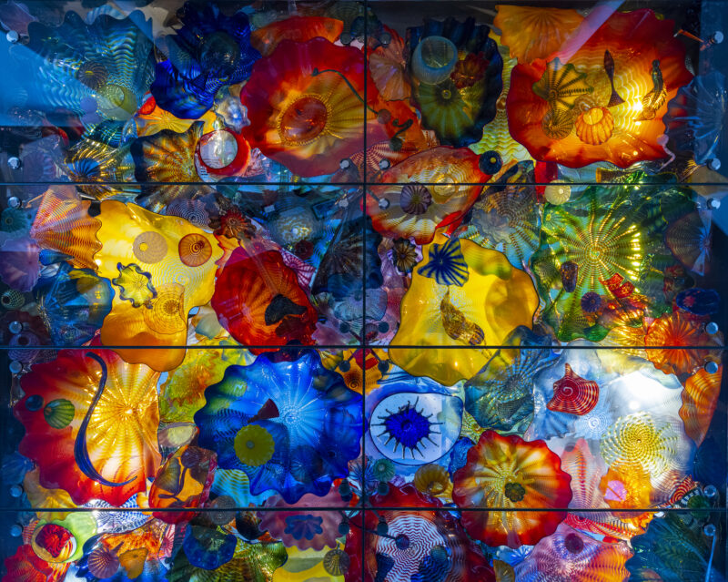 Colorful pieces of glass in various shapes assembled together in a rectangle pattern