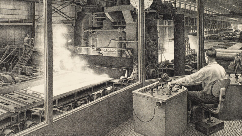 Man sitting at a chair in front of a panel of controllers in a manufacturing facility