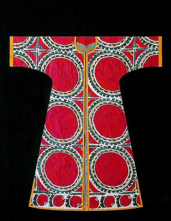 Photo of a kaftan made from paper that looks like real fabric. Large red circles surrounded by an orange, blue, and green print.