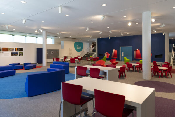 Photo of tables, chairs and walls in the museum's Living Room area