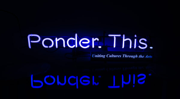 Neon blue text Ponder. This on a black baclground with a mirrored image below the text
