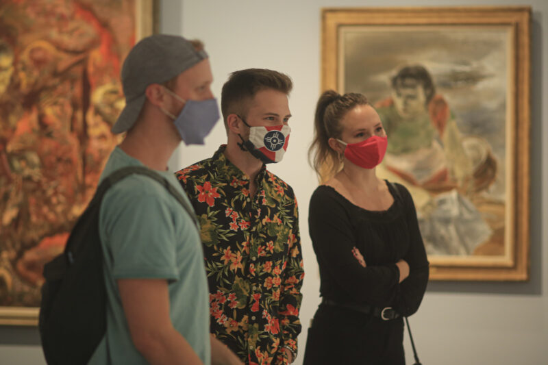 Interior view of visitors in the galleries wearing masks